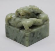 A Chinese green stone 'dragon' seal, the top carved in open work and high relief with a curling