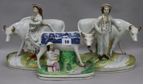 A pair of 19th century Staffordshire porcelain groups of a dairy boy and a dairy girl standing by