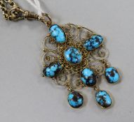 An early 20th century 9ct gold and turquoise set filligree pendant on a 9ct gold chain, pendant