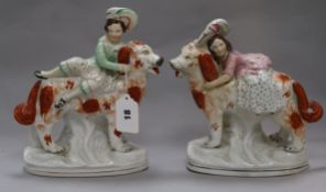 A pair of Staffordshire groups of a Prince and Princess riding dogs H 32cms