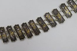 A Japanese mixed metal bracelet with twelve decorated rectangular plaques, 18.5cm.