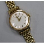 A lady's 9ct Longines manual wind wrist watch, on an 18ct gold bracelet.