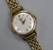 A lady's 9ct Longines manual wind wrist watch, on an 18ct gold bracelet.