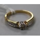 A solitaire diamond ring with diamond set shoulders, 18ct gold shank, size Q.