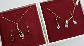 A blue topaz and 9ct gold necklace and earrings en suite and a 9ct gold and garnet openwork