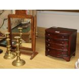A mahogany toilet mirror, a pair of Victorian brass candlesticks and a miniature bowfronted chest of