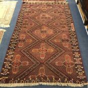 A rust and blue ground rug 241cm x140cm