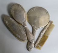 A four piece silver mounted mirror and brush set.