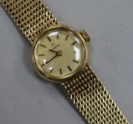 A lady's 9ct Omega manual wind wrist watch on integral Omega 9ct gold bracelet.