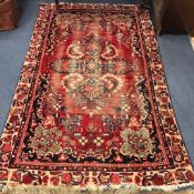 A red ground rug 218cm x135cm