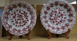 A pair of Chinese Ming-style underglaze copper red dishes, with wooden stands D.44cm