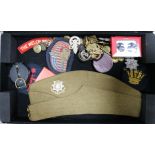 A collection of British military cap badges, buttons, etc.