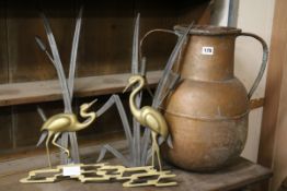 A brass and iron group of storks and an Eastern copper pot