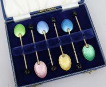 A cased set of enamel spoons