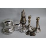 A pair of silver dwarf candlesticks, a silver caster, four silver wine labels and four toilet jars