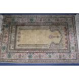 A cream ground Persian silk rug 113cm x 74cm