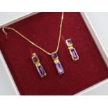 An amethyst and 9ct gold pendant and a pair of earrings en suite, the pendant on 18ct gold chain.