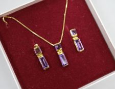 An amethyst and 9ct gold pendant and a pair of earrings en suite, the pendant on 18ct gold chain.