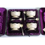 A cased set of four Victorian embossed silver salts and matching spoons, Sibray, Hall & Co,