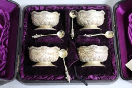A cased set of four Victorian embossed silver salts and matching spoons, Sibray, Hall & Co,