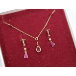 A ruby and 9ct gold pendant and a pair of earrings en suite, the pendant on 9ct gold fine chain with