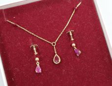 A ruby and 9ct gold pendant and a pair of earrings en suite, the pendant on 9ct gold fine chain with