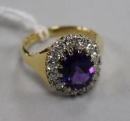 A modern 18ct gold, amethyst and diamond oval cluster ring, size L.