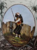A 19th century Continental porcelain plaque painted with a Moroccan soldier, housed in an ornate