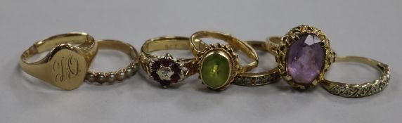 Six assorted 9ct gold rings including gem set and a yellow metal ring.