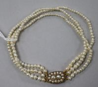 A late 19th/early 20th century triple strand seed pearl bracelet with seed pearl set yellow metal