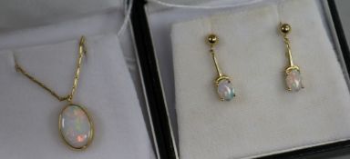 An 18ct gold and opal pendant on chain and a similar pair of opal and 14ct gold earrings.