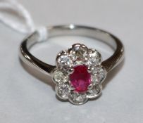 A white gold, ruby and diamond oval cluster ring, size N.