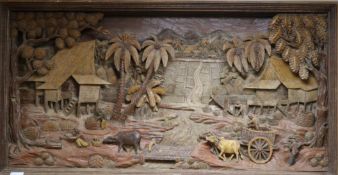 A large Thai hand-carved wood three dimensional picture, depicting farmers in a landscape 27in. x