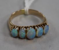 A yellow metal and graduated five stone white opal ring, size O.
