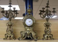 An early 20th century French cast brass three piece clock garniture H.69cm.