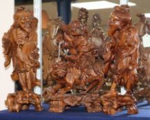 A pair of Chinese carved hardwood figures of fishermen and another figure of a demon riding a lion