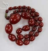 A single strand graduated simulated cherry amber oval bead necklace, gross weight 49 grams, 48cm.