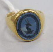 An early 20th century 18ct gold and blue chalcedony signet ring, carved with crested matrix, size