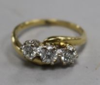 A modern 18ct gold and three stone diamond crossover ring, size R.