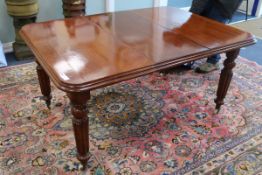 A mahogany windout dining table and one spare leaf extends to 148cm x 104cm
