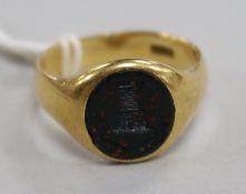An early 20th century 18ct gold and bloodstone signet ring with carved "turret" matrix, size R.