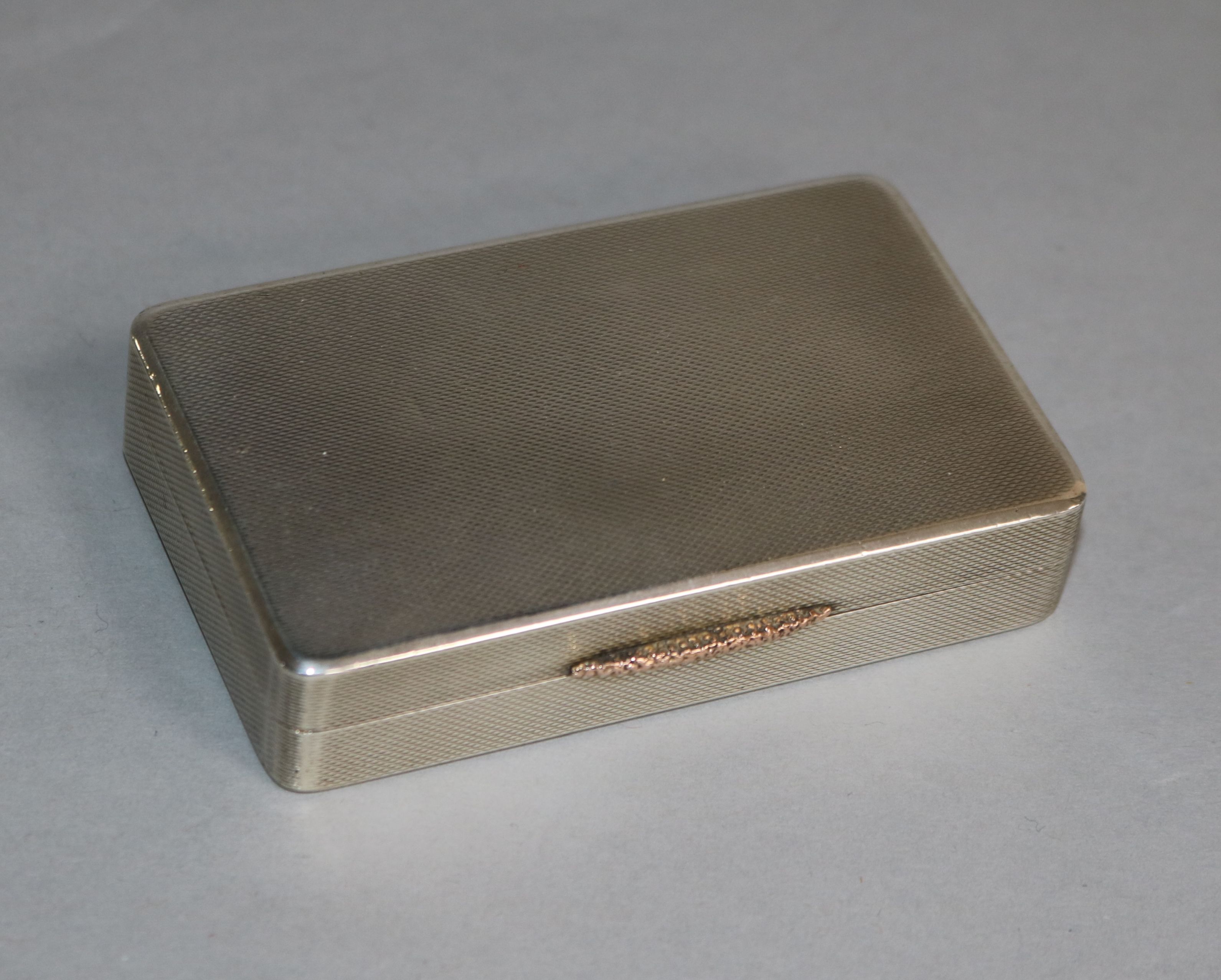 A George V engine turned silver snuff box, W.H. Manton Ltd, Birmingham, 1945, 82mm.