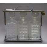 A 1930's chromed metal tantalus, fitted with three cut glass decanters, later padlock, 30cm