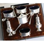 A cased George V silver seven piece condiment set by Walker & Hall, Birmingham, 1926.