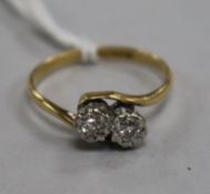 An 18ct gold and platinum, two stone illusion set diamond crossover ring, size N.