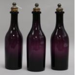 A set of three 19th century amethyst glass decanters, with plated stoppers, height 26cm