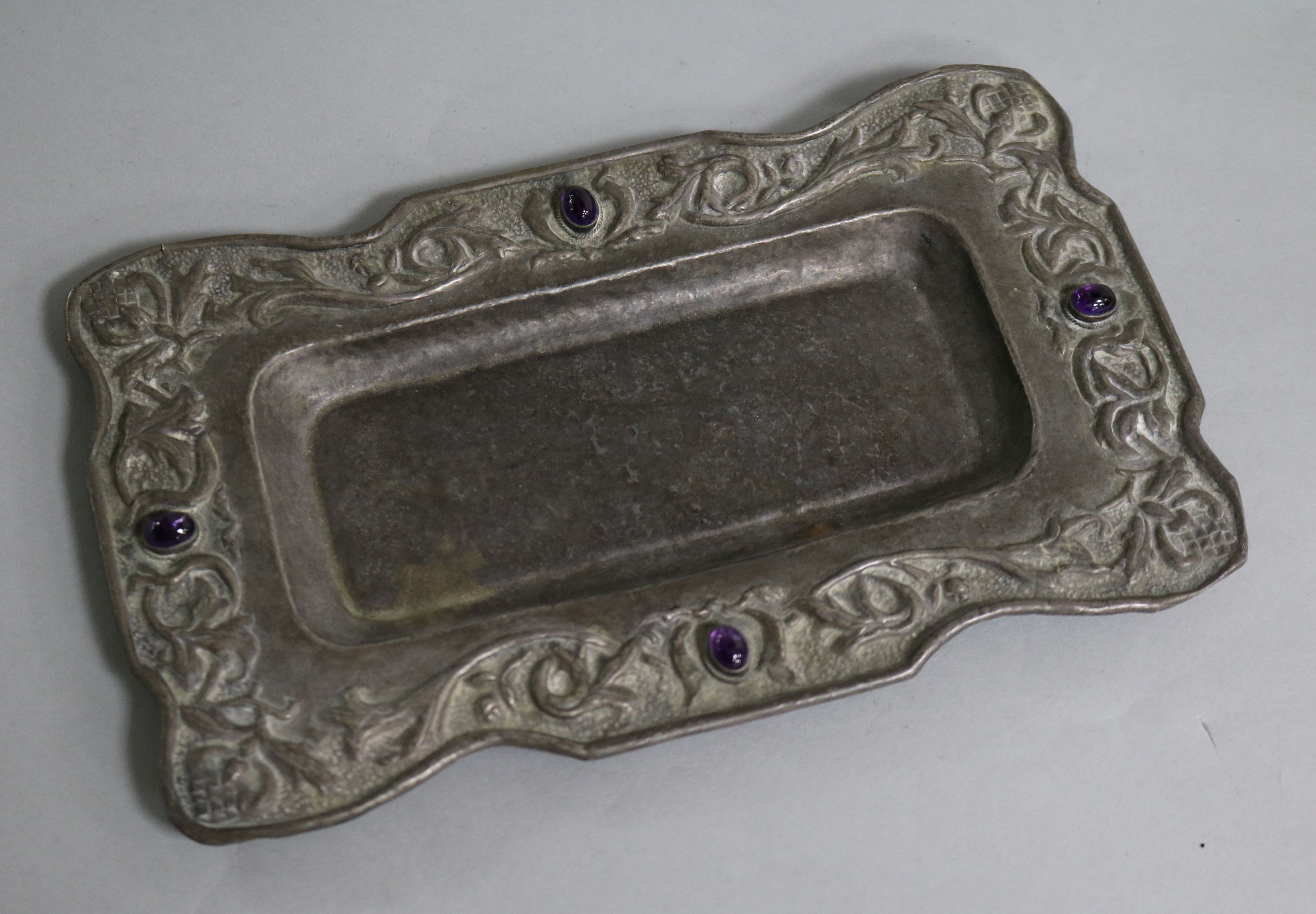 An early 20th century Arts & Crafts repousse white metal and cabochon amethyst set rectangular