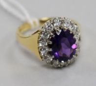 A modern 18ct gold, amethyst and diamond oval cluster ring, size L.