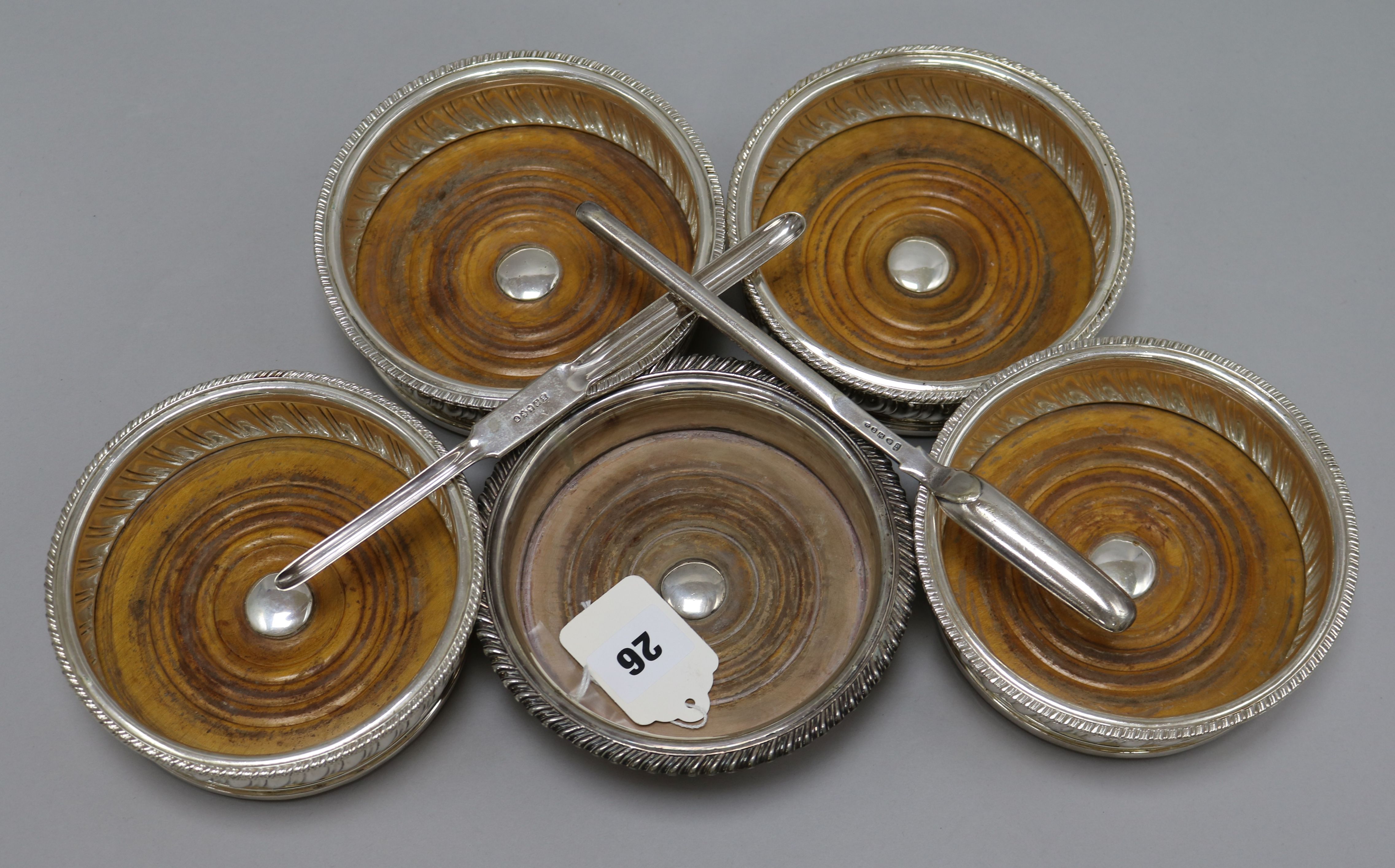 A set of four plated wine coasters, a similar coaster and two marrow scoops