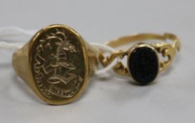 A 9ct gold signet ring with carved crested matrix and a 19th century yellow metal and black onyx